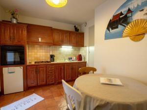 uma cozinha com uma mesa e uma cozinha com uma mesa e cadeiras em Appartement Biron, 2 pièces, 2 personnes - FR-1-616-122 em Biron
