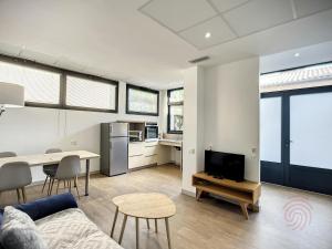 uma sala de estar com um sofá e uma mesa com uma televisão em Appartement Lamalou-les-Bains, 3 pièces, 4 personnes - FR-1-451-170 em Lamalou-les-Bains