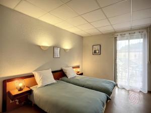 Posteľ alebo postele v izbe v ubytovaní Appartement au cœur de Lamalou-les-Bains, proche thermes et centre-ville, avec balcons et Wifi. - FR-1-451-172