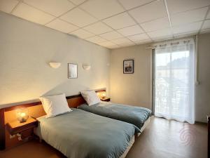 Posteľ alebo postele v izbe v ubytovaní Appartement au cœur de Lamalou-les-Bains, proche thermes et centre-ville, avec balcons et Wifi. - FR-1-451-172