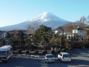 una montaña cubierta de nieve con coches aparcados en un aparcamiento en Fujimien, en Fujikawaguchiko