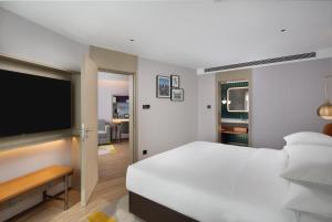 a bedroom with a white bed and a flat screen tv at Home2 Suites by Hilton Beijing West Station in Beijing
