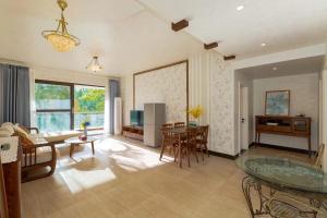uma sala de estar com uma mesa de vidro e cadeiras em Sunny Apartment, minutes to beach em Shuijiao