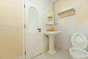 a white bathroom with a toilet and a sink at Sunny Apartment, minutes to beach in Shuijiao