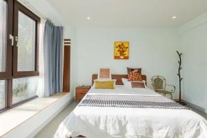 a bedroom with a large bed and windows at Sunny Apartment, minutes to beach in Shuijiao