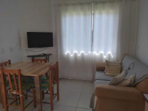 a living room with a table and a couch at Residencial da Praia 2 in Arroio do Sal