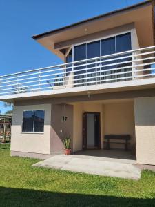 a house with a balcony with a bench on it at Residencial da Praia 2 in Arroio do Sal