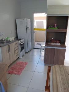 a kitchen with a refrigerator and a table in it at Residencial da Praia 2 in Arroio do Sal