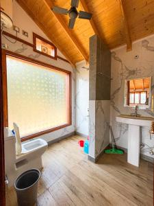 a bathroom with a toilet and a sink and a window at Camp Banas Naudhiya in Budia