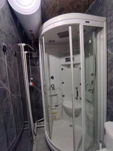 eine Dusche mit Glastür im Bad in der Unterkunft Cottage town D&N in Karakol