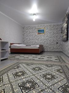 a bedroom with a bed and a rug on the floor at Cottage town D&N in Karakol