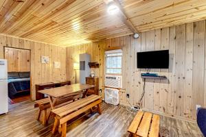 een eetkamer met een tafel en een tv in een hut bij Dragonfly Gully in Rhinelander