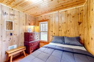 een slaapkamer met een bed en een houten muur bij Dragonfly Gully in Rhinelander