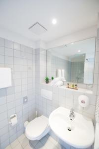 a white bathroom with a toilet and a sink at Bischofshol in Hannover