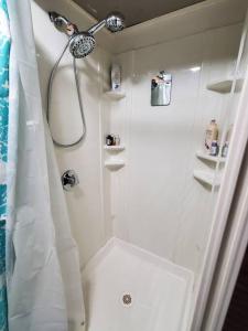 baño blanco con ducha y lavamanos en Tranquil 4br lakefront home with wrap around deck, en Warner