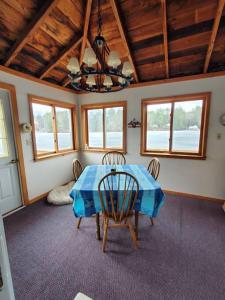comedor con mesa azul y sillas en Tranquil 4br lakefront home with wrap around deck, en Warner