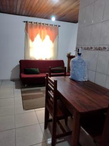 a living room with a wooden table and a couch at Chalés lima in Monte Verde