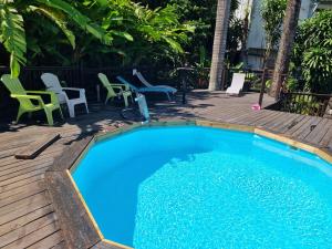 una piccola piscina su una terrazza con sedie e tavoli di Bungalow Jamaïque a Deshaies