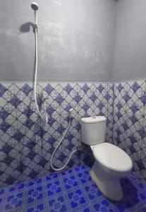 a bathroom with a toilet and a shower at Raja Ampat Sandy Guest House in Saonek