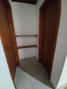 a small hallway with a door and shelves in a room at Chalés lima in Monte Verde