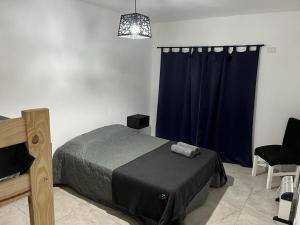 艾塞薩的住宿－Travel Suites Ezeiza，一间卧室配有床和蓝色窗帘