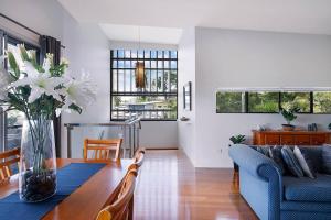 a living room with a table and a blue couch at Top of Taringa Penthouse with Sweeping Views in Brisbane