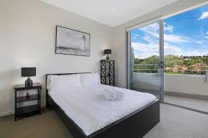 a bedroom with a bed with two white towels on it at Top of Taringa Penthouse with Sweeping Views in Brisbane