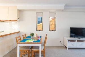 una cucina e una sala da pranzo con tavolo e sedie di The Hidden Flower - A Spacious Poolside Abode a Brisbane