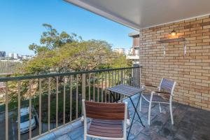 d'une terrasse avec une table et deux chaises sur un balcon. dans l'établissement The Hidden Flower - A Spacious Poolside Abode, à Brisbane