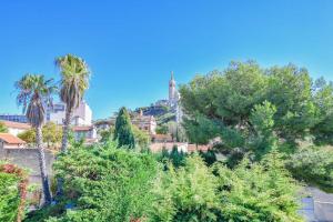 a view of a hill with trees and a church at Villa Notre-Dame - Piscine parking 4 chambres in Marseille
