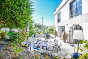a patio with a table and chairs and a building at Villa Notre-Dame - Piscine parking 4 chambres in Marseille