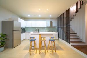 a kitchen with a sink and two bar stools at Luodong warm house in Luodong