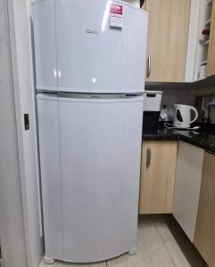 a white refrigerator and freezer in a kitchen at Apartamento Beira mar Capão da Canoa in Capão da Canoa