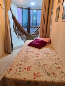 a bed in a room with a hammock at Apartamento Beira mar Capão da Canoa in Capão da Canoa