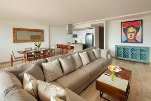 een woonkamer met een bank en een eetkamer bij Luxurious Ocean View Apartment in Cabo San Lucas