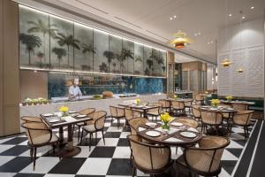 a dining room with tables and chairs in a restaurant at Citadines Hope City Boao in Qionghai