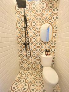 bagno con servizi igienici e specchio di Casa Bonita: Stylish, Affordable Home & Mini Pool a Kalasan