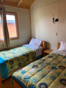 um quarto com duas camas e uma janela em Cabaña Paso De Los Toros, San Fabian de Alico em San Fabián de Alico