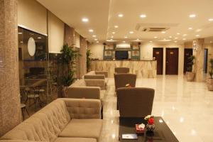 un vestíbulo con sofás y sillas y un bar en Plaza Home en Al Khobar