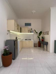 una cucina con pavimenti piastrellati bianchi e frigorifero nero di Casa Bonita: Stylish, Affordable Home & Mini Pool a Kalasan