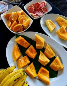 trois plaques alimentaires avec des oranges et des fruits sur une table dans l'établissement Vaea Hotel Samoa, à Apia