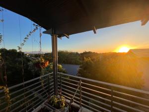 a view of the sunset from the balcony of a house at Baha Sanctuary House - 3 Bedroom House with Pool in Plettenberg Bay