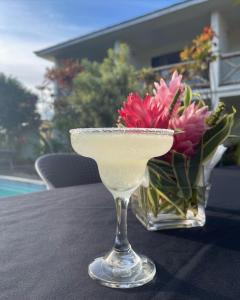 a martini glass sitting on a table with a vase of flowers at Vaea Hotel Samoa in Apia