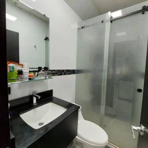 a bathroom with a toilet and a sink and a shower at departamento con piscina y áreas sociales in Santo Domingo de los Colorados