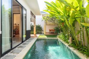 a pool in the middle of a house with plants at Kamaratih Villas by Maheswara in Legian
