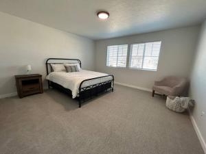 a bedroom with a bed and a chair and a window at Countryside Classic in Nampa