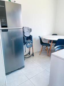 eine Küche mit einem Kühlschrank und einem Tisch mit Stühlen in der Unterkunft Casa aconchegante em São Gabriel in São Gabriel
