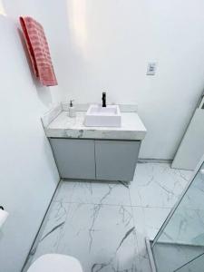 ein weißes Bad mit einem Waschbecken und einem WC in der Unterkunft Casa aconchegante em São Gabriel in São Gabriel
