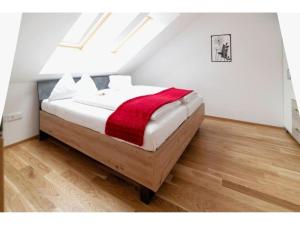 Apartment in Hohentauern with sauna في هوهنتاورن: غرفة نوم مع سرير مع بطانية حمراء عليه