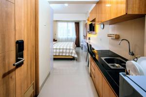 a kitchen with a sink and a bed in a room at Padina Soho And Residence in Kebonbesar
